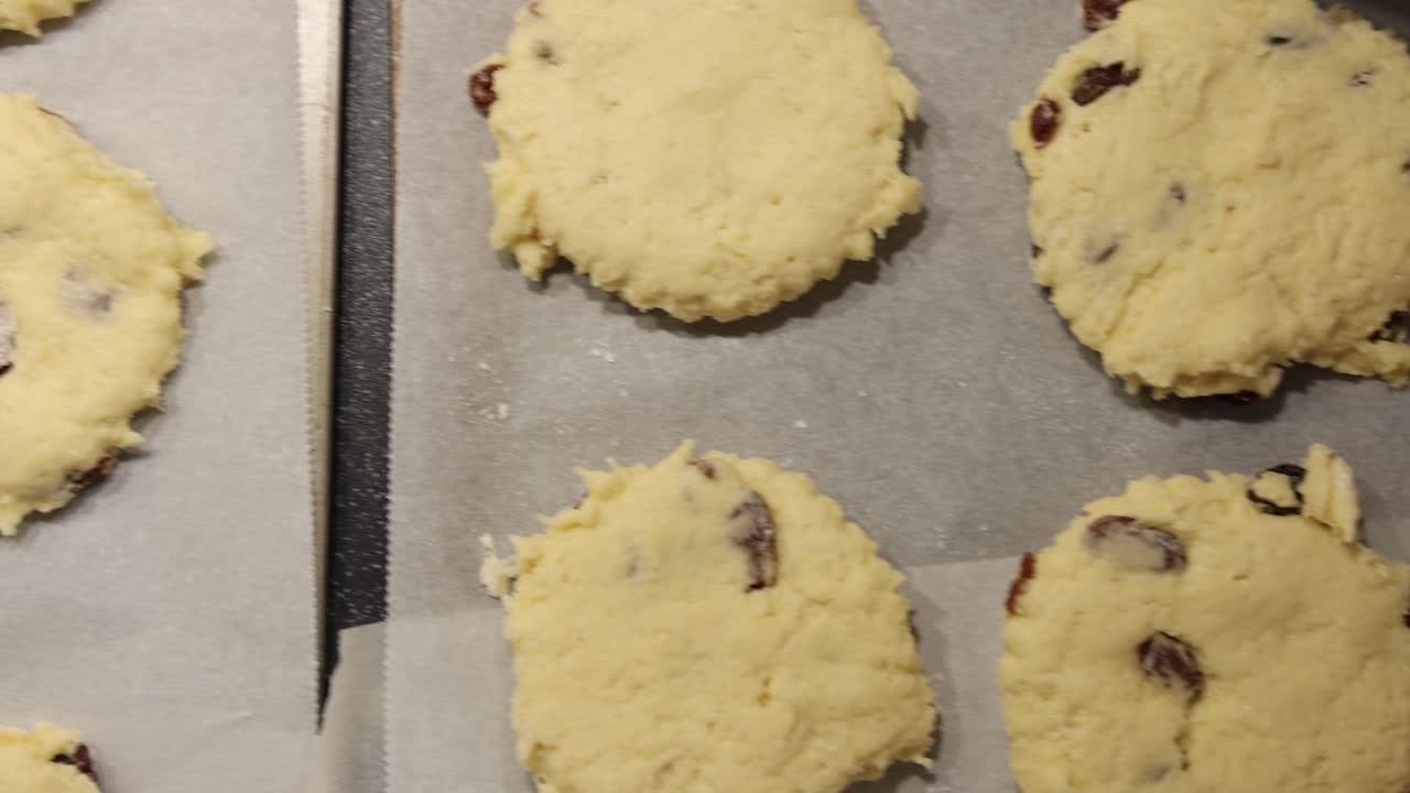 Slow dolly shot of trays of uncooked scones ready to be cooked in the oven