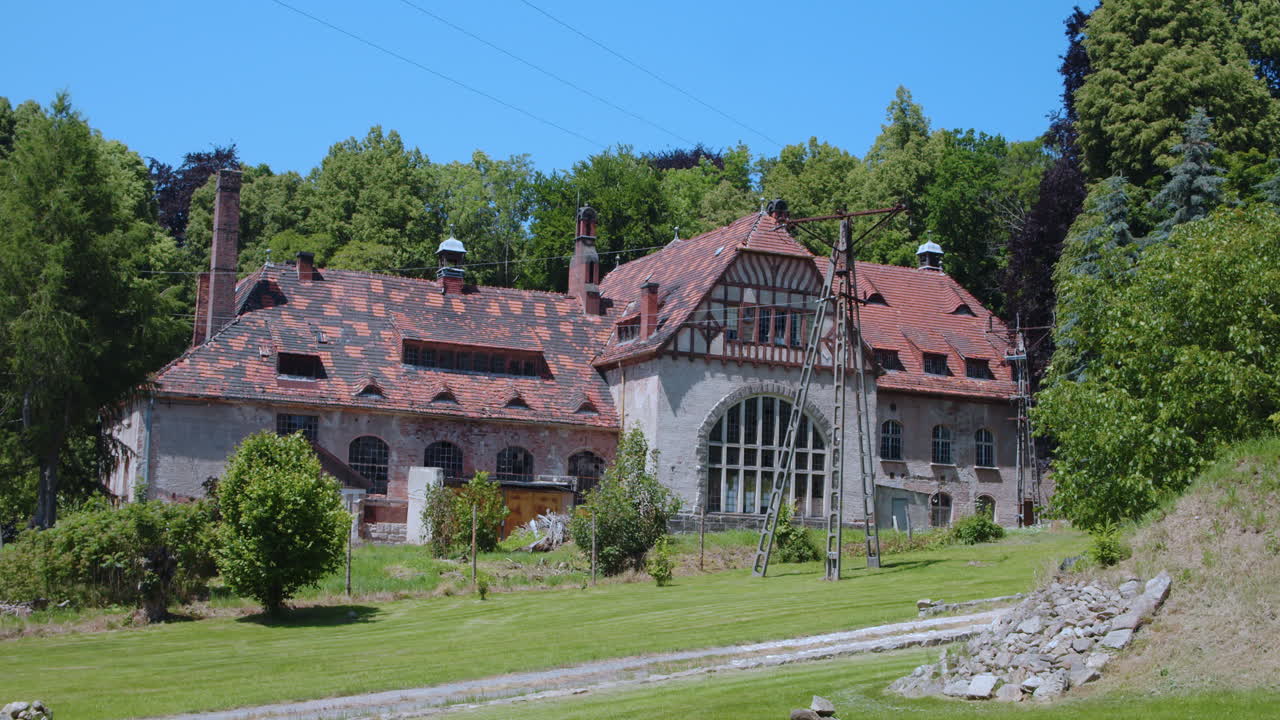 Old abandoned building with brick roof surrounded by forest