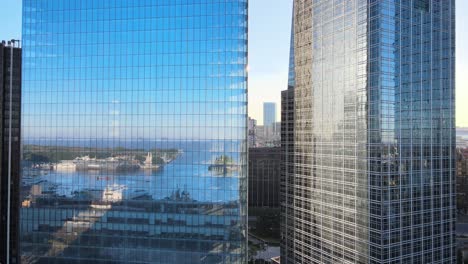 close up aerial pan shot looking at modern high-rise skyscrapers with reflective glass window mirroring puerto madero harbor in downtown of buenos aires, argentina