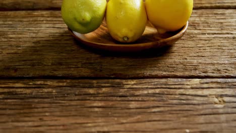 Lemons-in-a-plate-on-wooden-table-4k