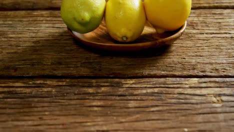 limones en un plato en una mesa de madera 4k