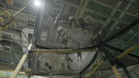 people playing on an indoor suspended net playground