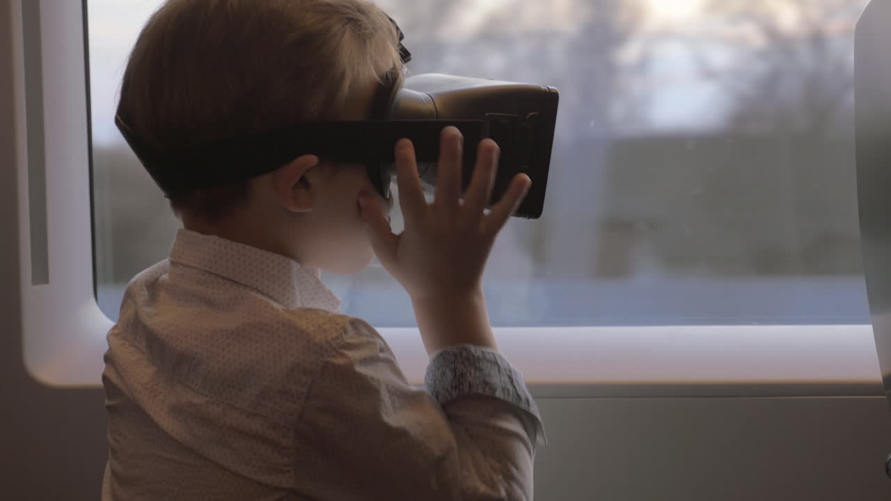 en san petersburgo, rusia, en un tren viaja un niño con gafas de realidad virtual.