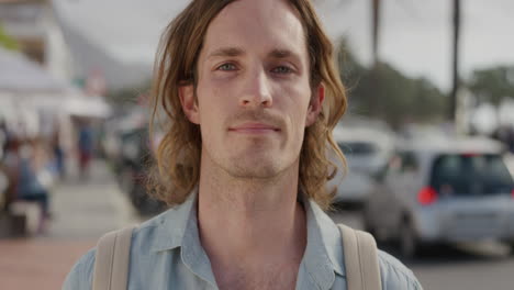 portrait of young caucasian man looking serious at camera handsome male tourist on sunny urban beachfront street slow motion