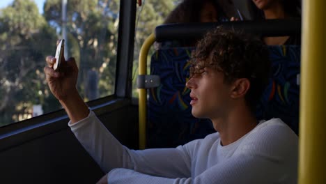 male commuter clicking photos with mobile phone while travelling in bus 4k