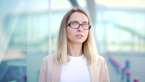 close up portrait young blonde business woman with glasses looking at camera. face confident female businesswoman