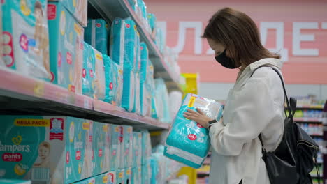 woman shopping for baby diapers in a supermarket