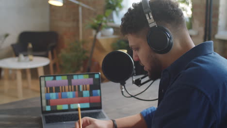 podcaster putting on headphones and writing on speech on paper