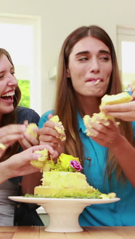 amigos felices comiendo pastel con las manos