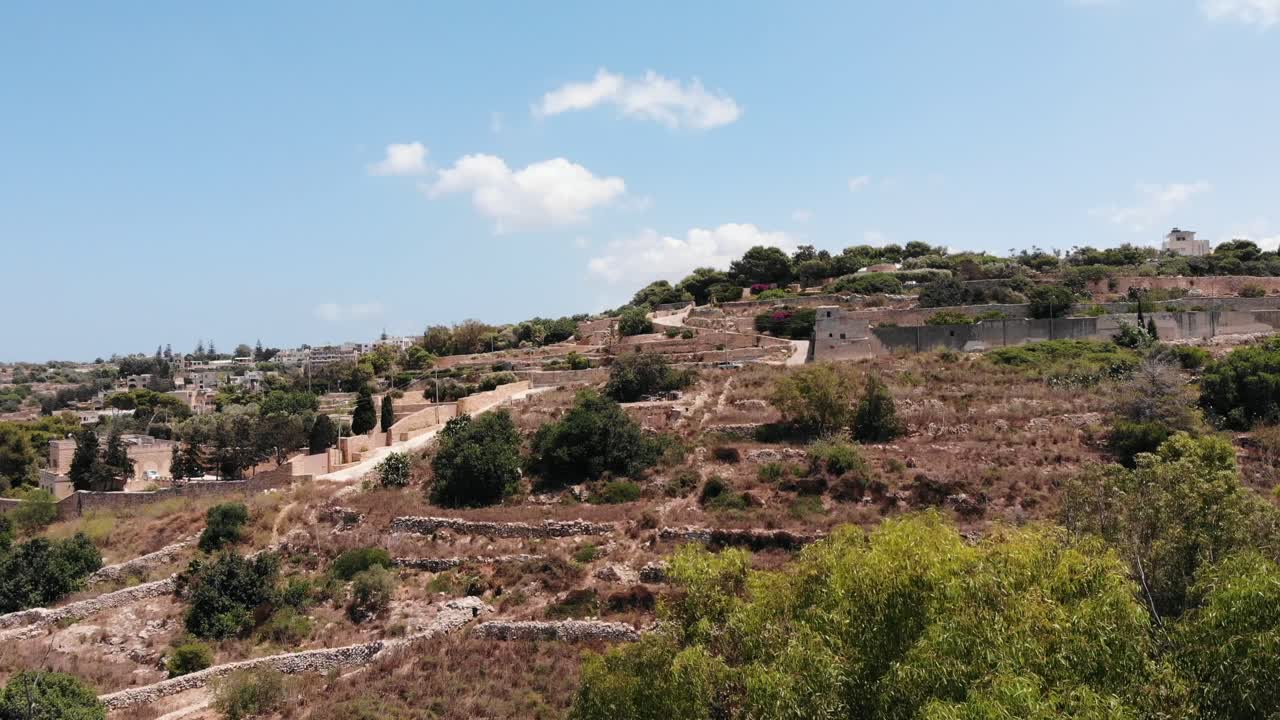 vista aérea ascendente de los campos rurales de la isla de malta en un día soleado de verano desde la cima del mundo, gharghur