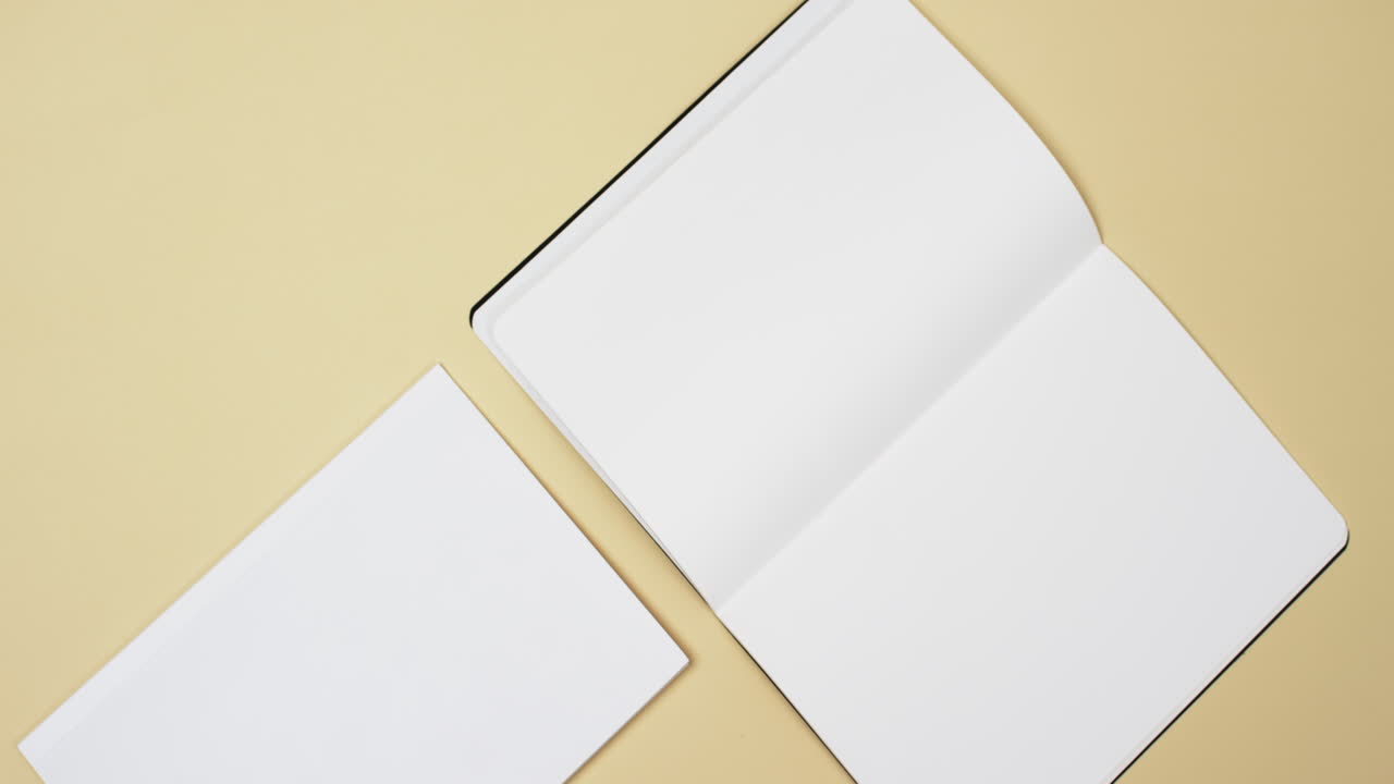Video of books with white blank pages and copy space on yellow background