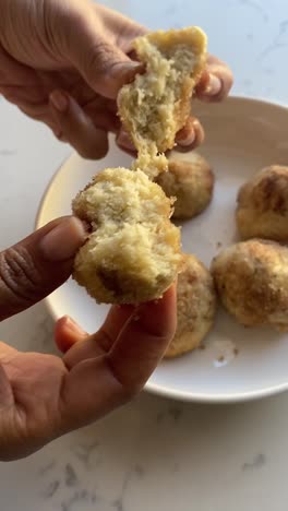 Vertical-video-of-Breaking-open-a-vegan-donut-fresh-from-the-air-fryer