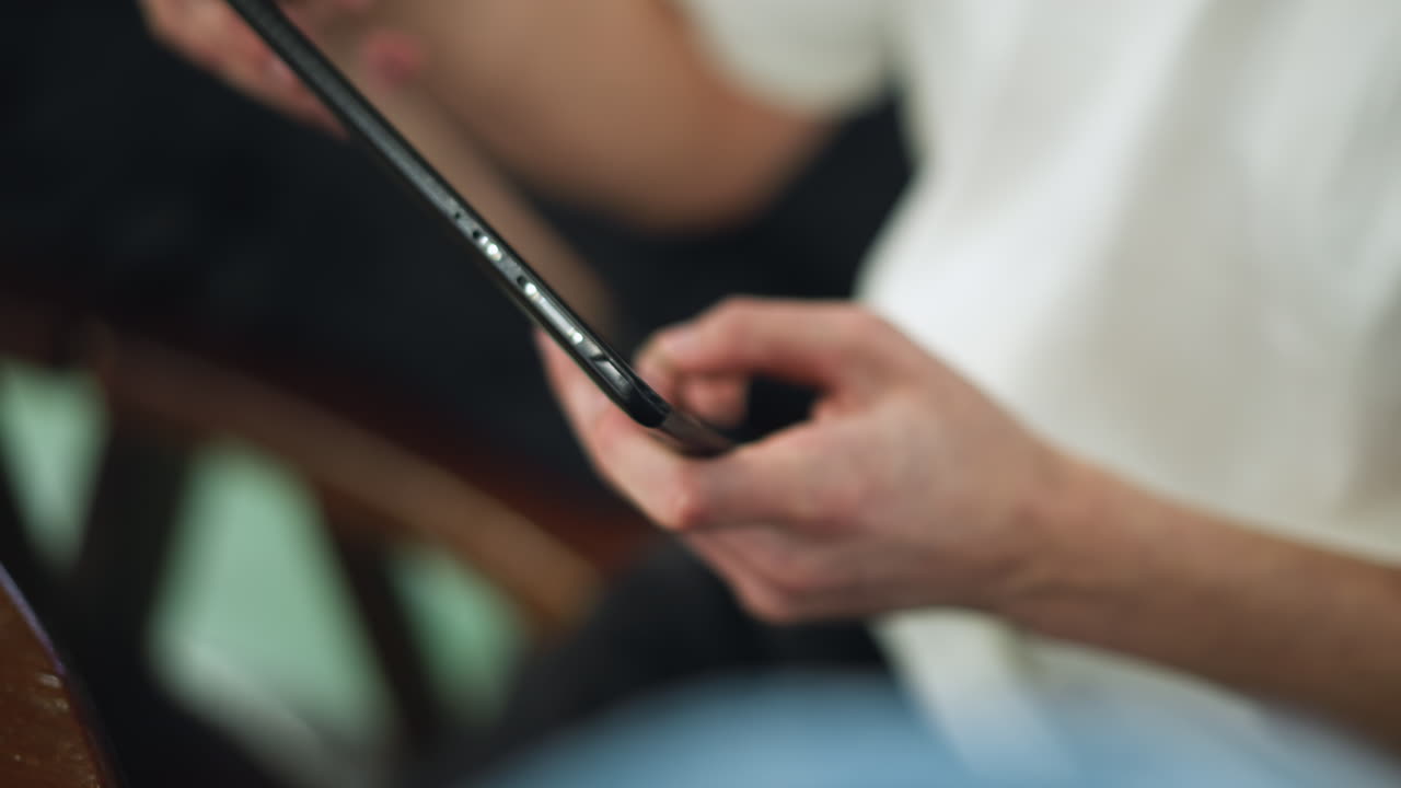 Primo piano di una mano che piega le dita mentre tocca lo schermo del tablet come se impugnasse un volante, simulando un movimento di guida sull'interfaccia touchscreen con un gesto sottile che imita la sfumatura della sensazione di guida reale.