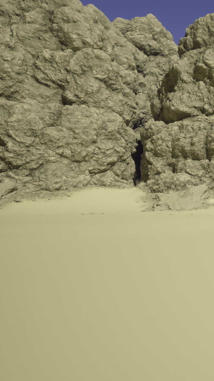Ujevne steiner og fin sand i et kystområde under klare dagslystimer.