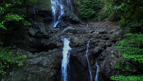 a steady drone shot lingers at the base of the waterfall, slowly revealing cascading water’s power and lush surroundings at balagbag falls, real, quezon, drawing viewers into nature’s rhythm