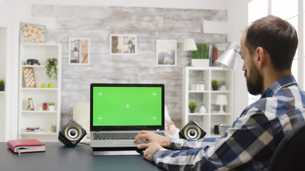 hombre trabajando en una computadora portátil con pantalla verde
