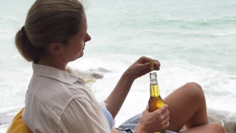 mujer disfrutando de una cerveza en la playa