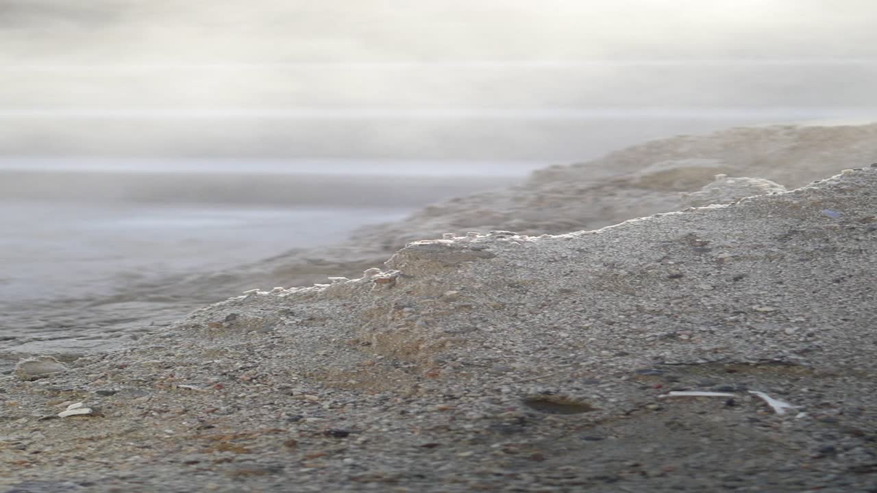 지열 온천 근처 의 증기 를 내는 모래 의 근접 사진