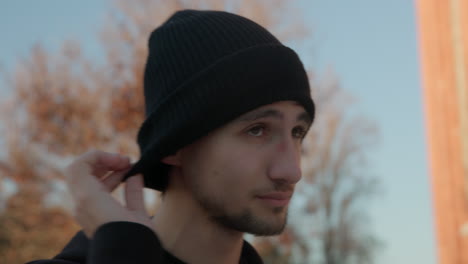 a young man putting earphones in his ears, close-up