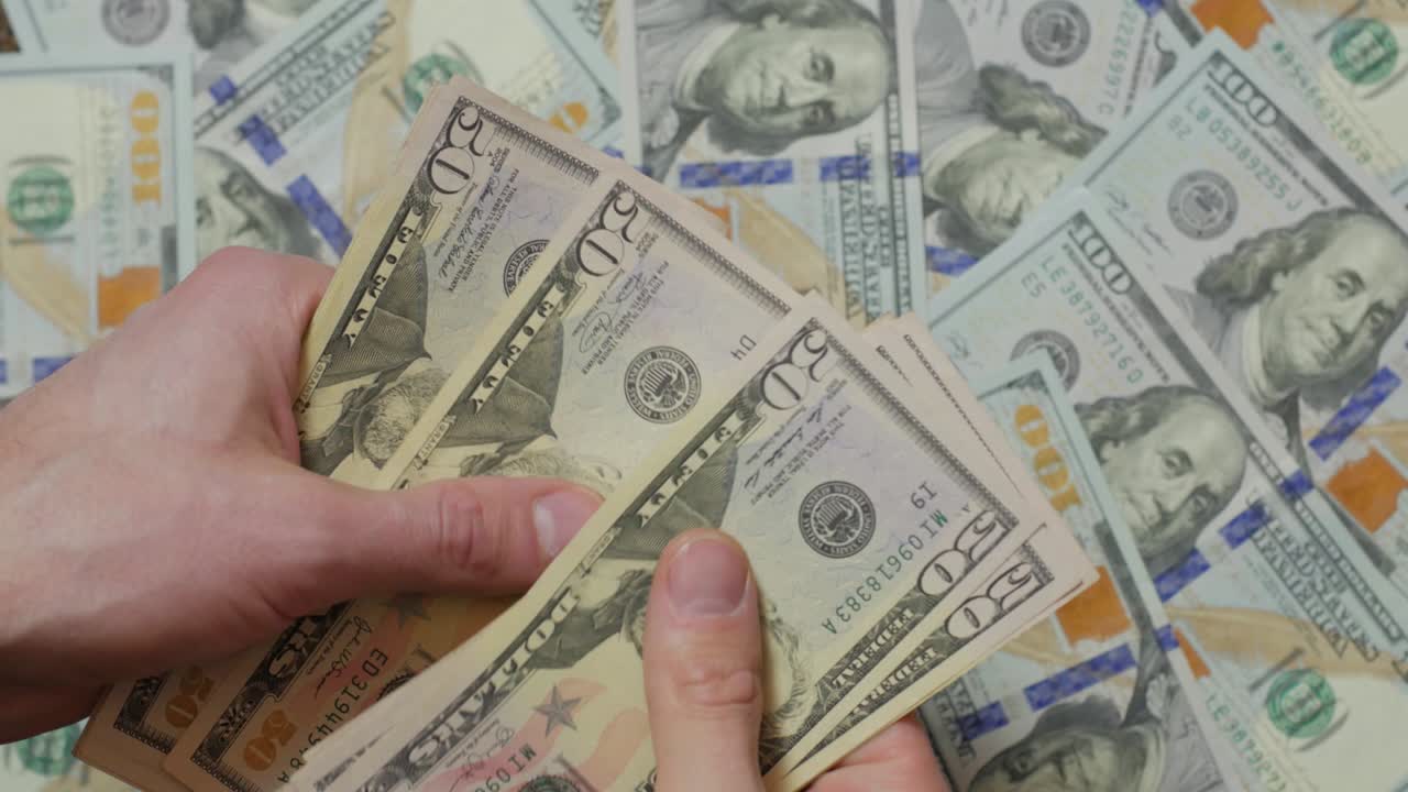 cuenta el montón de dólares.