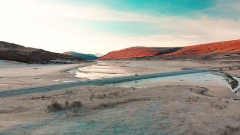 Aerial-view-across-Múlaþing-sunset-mountain-with-infrared-like-arctic-landscape,-Iceland