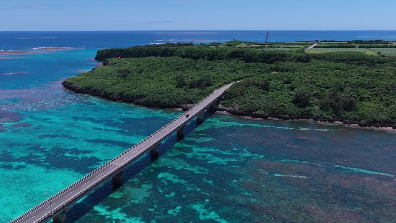 Riprese aeree orizzontali con drone che avanza sopra il Ponte Kurima che attraversa le acque turchesi della barriera corallina verso l'isola di Kurima, Miyakojima, Okinawa, Giappone