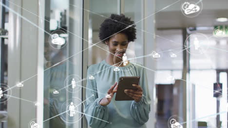 Animation of network of connections with people icons over african american woman using tablet