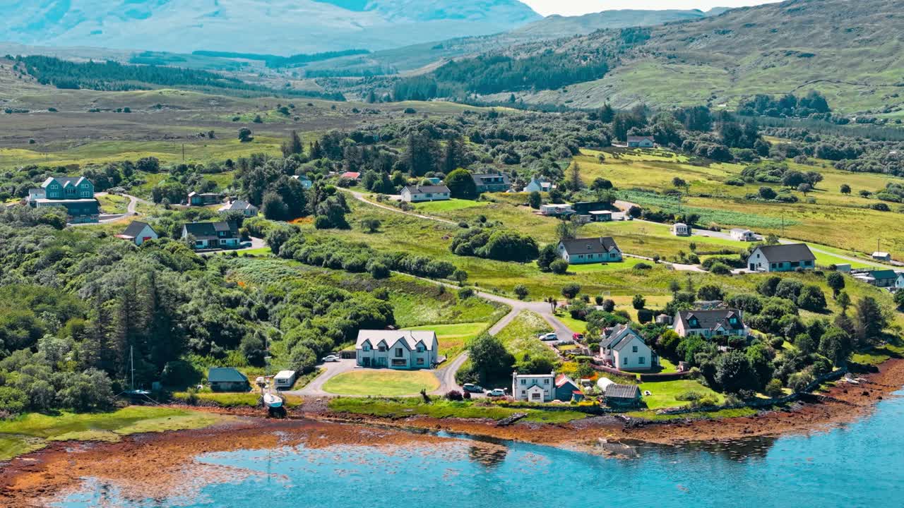 Aerial view of a scenic town nestled in a green landscape with mountains and water