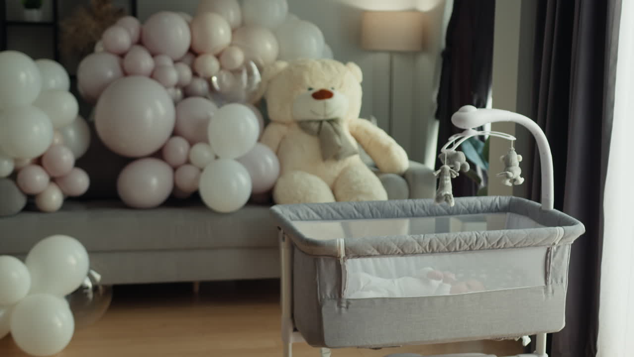 Orsetto di peluche e palloncini decorano la stanza per l'arrivo di un neonato, creando un'atmosfera festosa