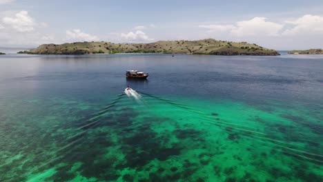 Experience-the-voyage-from-a-small-boat-to-a-larger-main-boat,-capturing-the-transition-and-the-scenic-surroundings-of-the-open-water