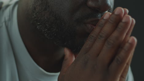 close-up of african american man praying with hands together