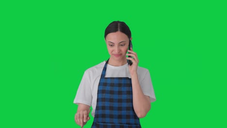 happy indian housewife talking on call while making food green screen