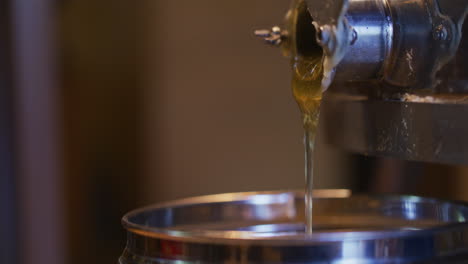 honey pouring from centrifuge into jar