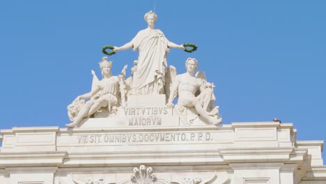 A-close-view-of-the-statues-at-the-top-of-the-Rua-Augusta-Arch-of-Praça-do-Comerica,-who-is-rewarding-both-Valour-and-Genius,-The-two-seated-figures-represent-the-two-mighty-rivers-in-Portugal