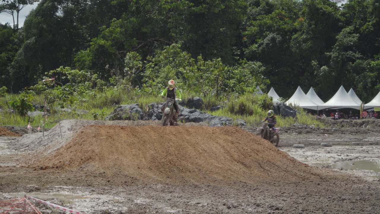 Motocross Race: Riders Jump and Race Through Muddy Terrain