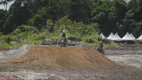 motocross race: riders jump and race through muddy terrain
