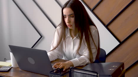 a woman is working with her laptop in an office