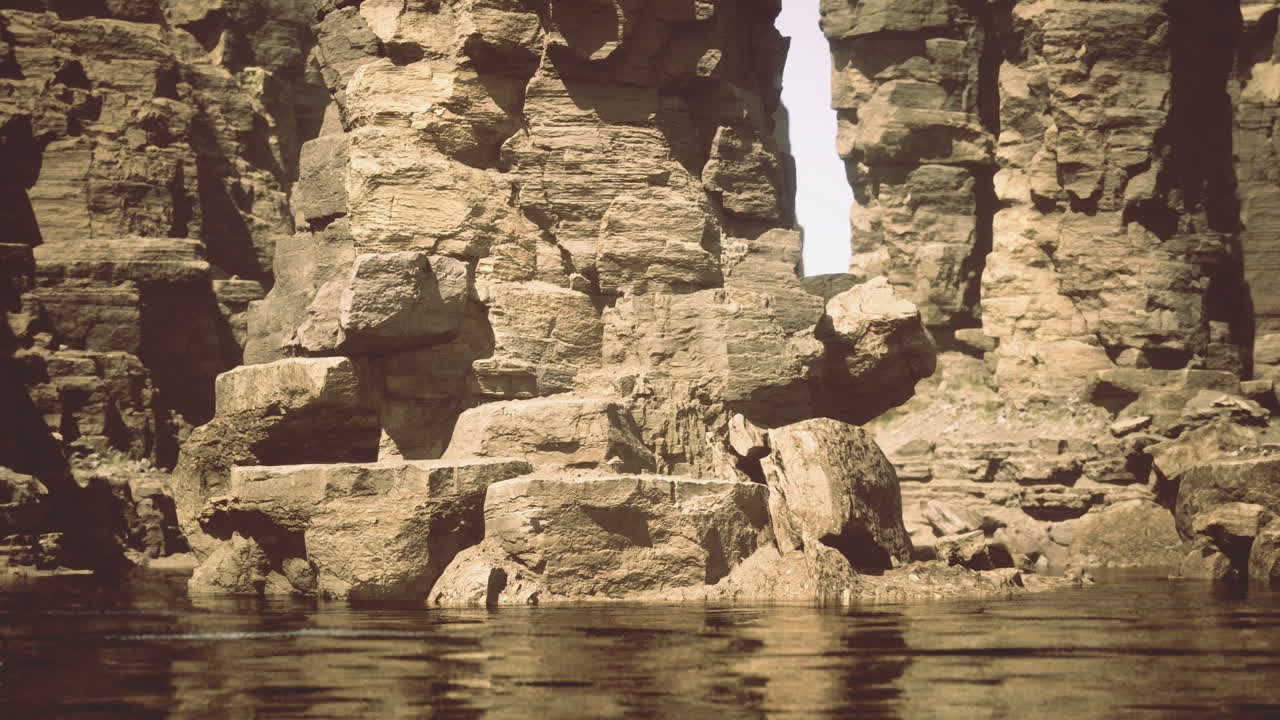 Rugged cliffs rise above reflective waters in a serene wilderness landscape