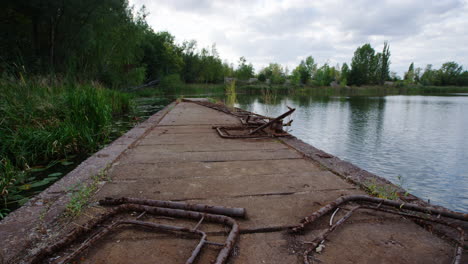 Pan-right-shot-of-a-pier,-forest,-and-peaceful-Prypiat-river,-Ukraine