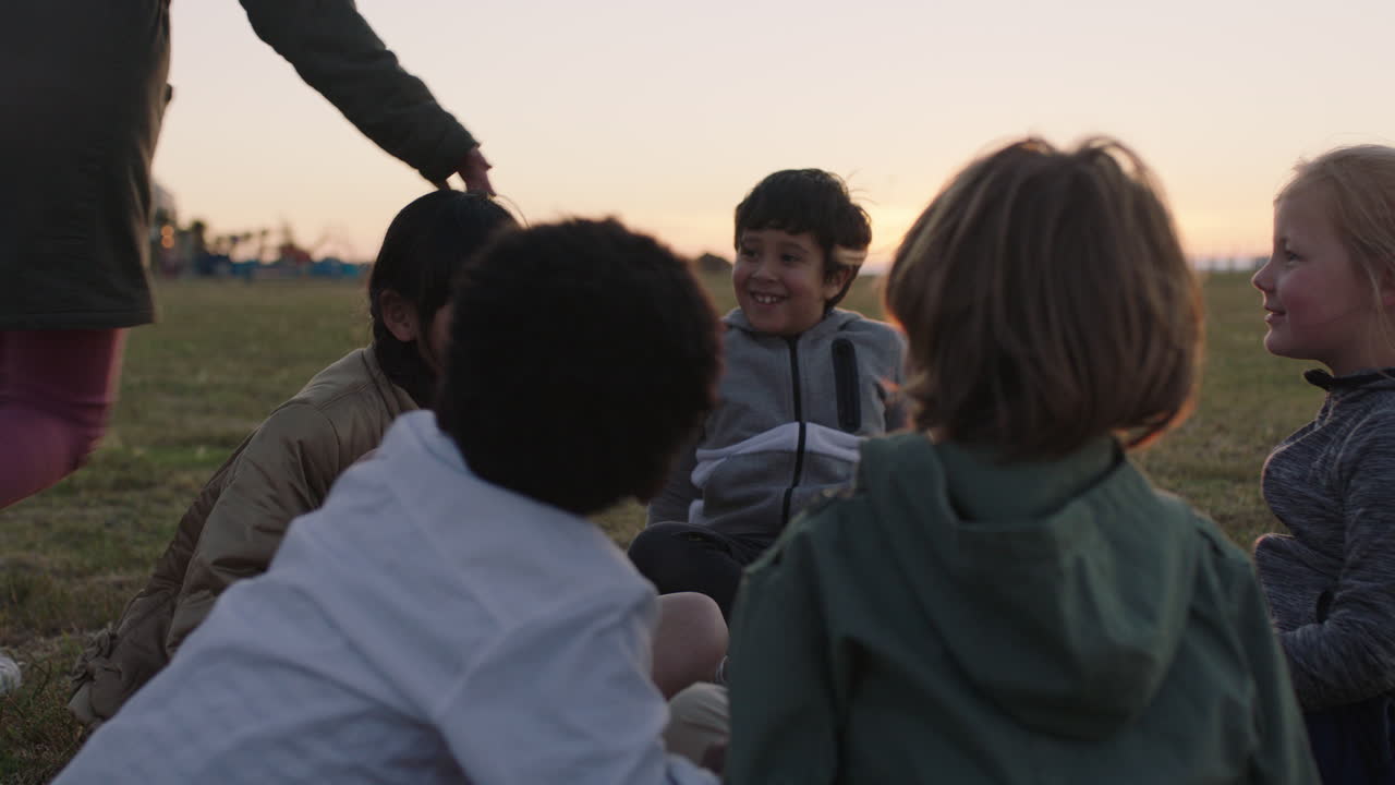 잔디 ⁇  에 앉아서 함께 놀고 일몰 에 즐거운 휴가를 즐기는 행복 한 어린이 들 의 초상화