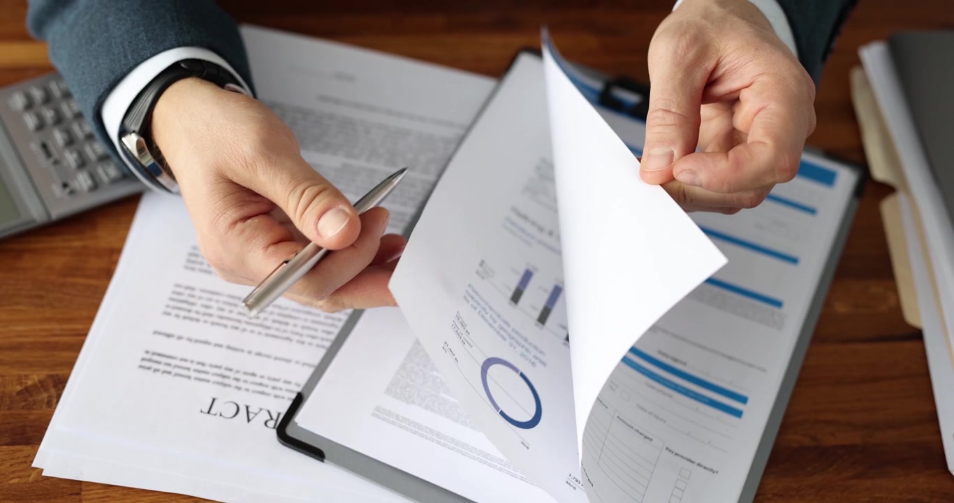 Businessman flips papers on clipboard preparing legal contract