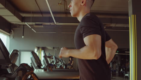 athletic man running on treadmill in gym