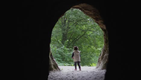 Verlorenes-Kind-Kleines-Mädchen,-Das-Aus-Einem-Höhleneingang-Geht