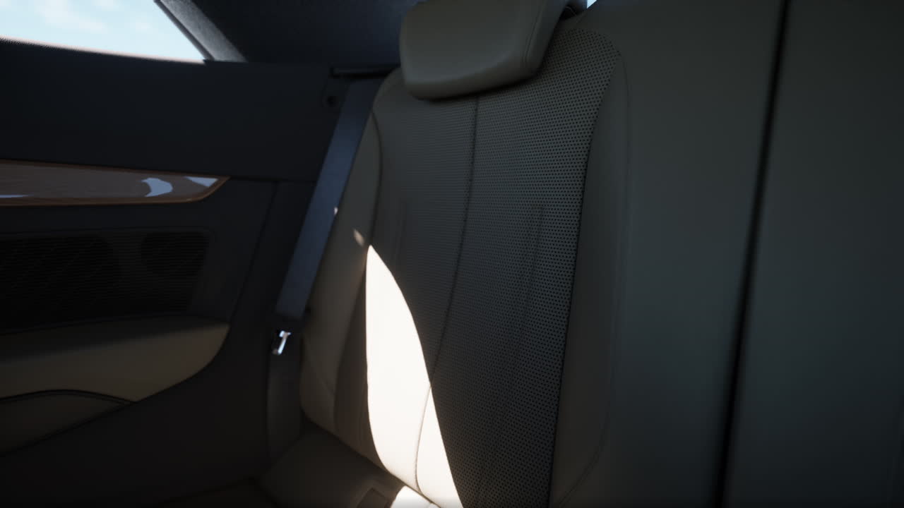 primer plano de un lujoso interior de coche con asientos de cuero beige y cuero perforado.