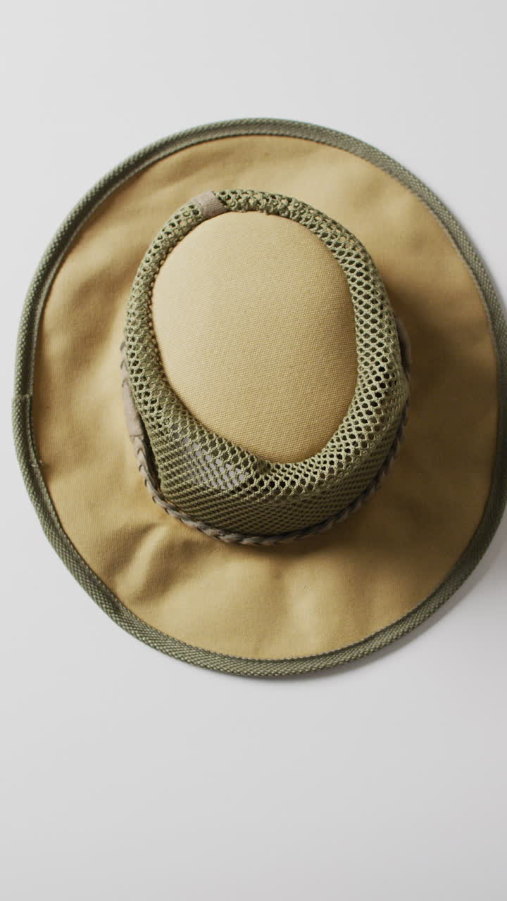 Vertical video of camping equipment with hat and copy space on white background