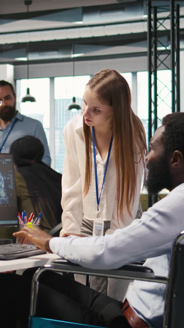 Vertical video Junior dev and coworker in wheelchair developing AI software applications