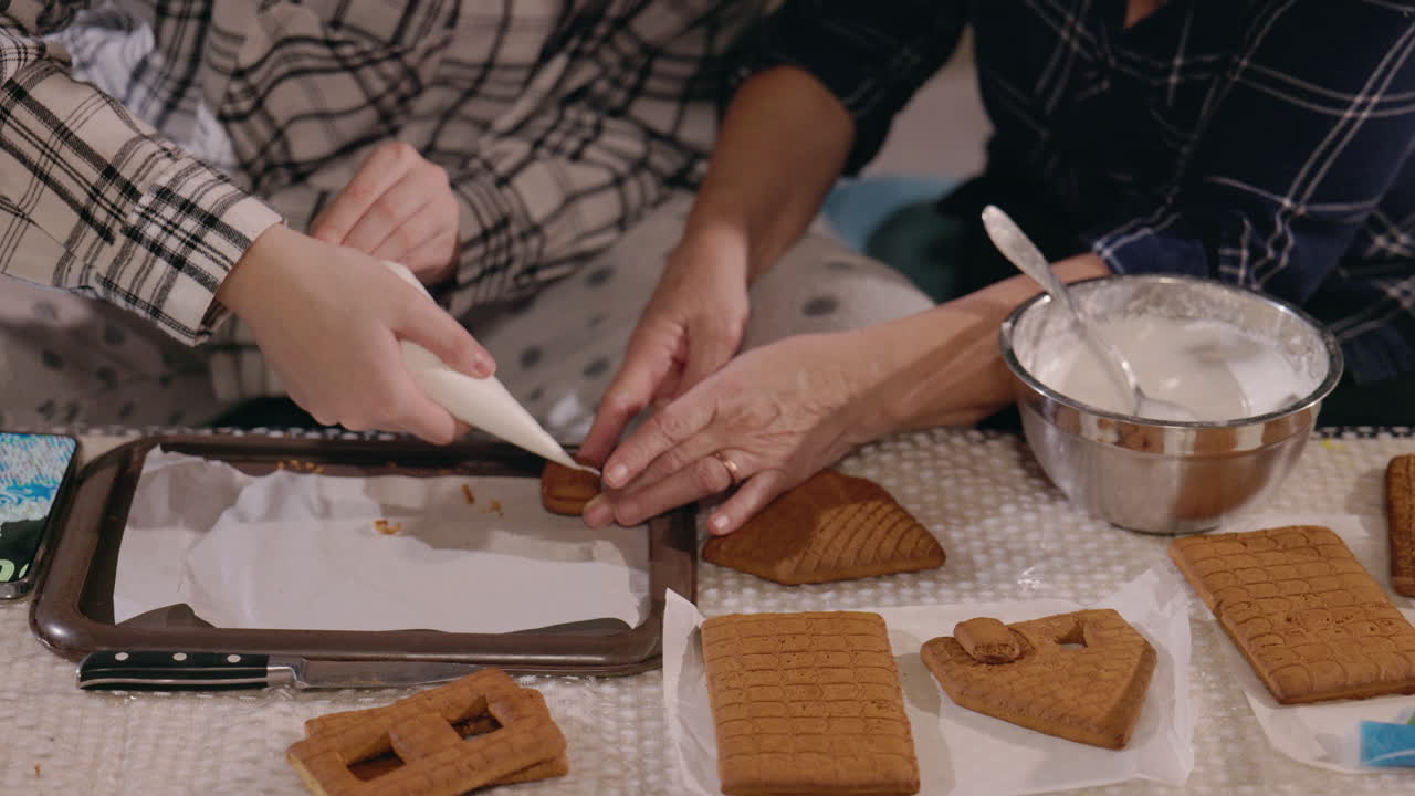 abuela y nieto decorando casas de pan de jengibre