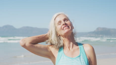 Senior-woman-smiling-and-looking-at-camera-on-the-beach