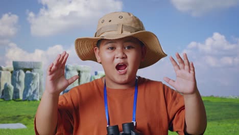 Asian Boy With A Hat Saying Wow After Looking Through The Binoculars. Boy Researcher Examines Something While Traveling In Stonehenge, Travel Tourism Adventure Concept, Close Up