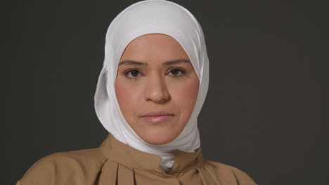 close up studio head and shoulders portrait of muslim woman wearing hijab